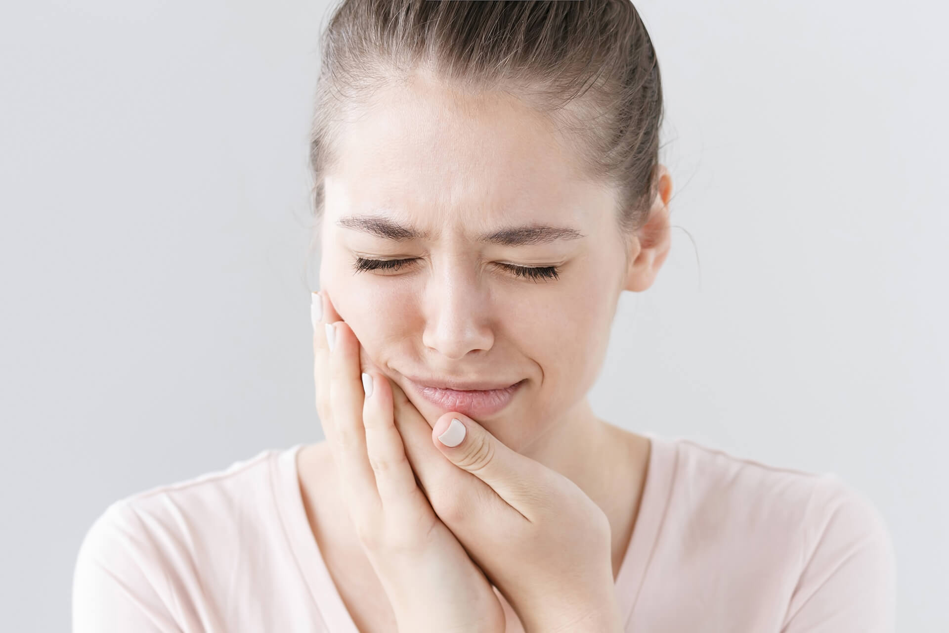 girl holding jaw in pain